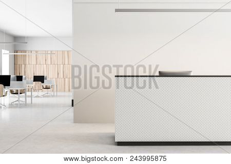 White Reception Desk Standing On A Concrete Floor Of A Modern Office. An Open Space Office Area In T