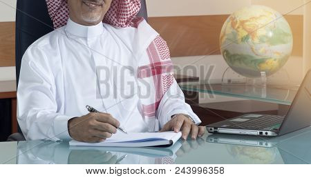 Senior Saudi Businessman Hand Writing At His Desk