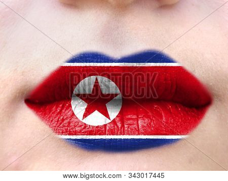 Female Lips Close Up With A Picture Flag Of North Korea. Learning Languages.
