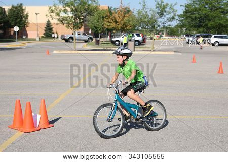 Young boy riding his bike during  a triathlon going around cones along the route