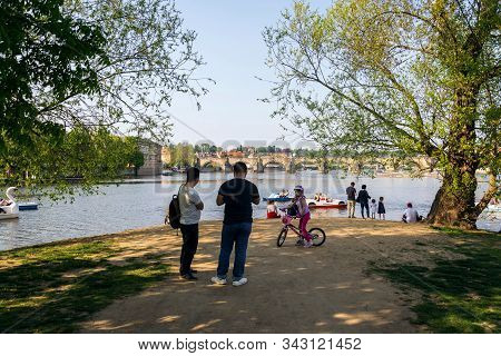Prague, Czech Republic - April 21 2018: Tourist Walking On The Strelecky Island With Weir On Vltava
