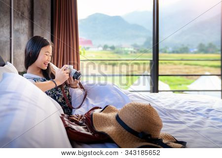 Thai Girl Relax In Bed Room With Country Background And Check Her Photo From Her Camera In Her Home 