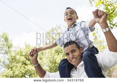 Hispânico pai e filho, tendo o divertimento andar junto no pai volta no Parque.