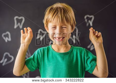 Litle Caucasian Boy Holds A Dropped Milk Tooth Between His Fingers And Laughs Looking Into The Camer