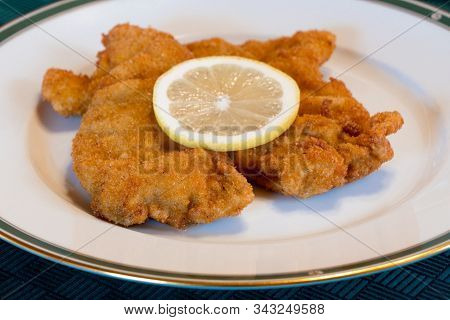Tasty Viennese Schnitzel Or Wiener Schnitzel On An Elegant Plate With Lemon, Traditional Austrian Di