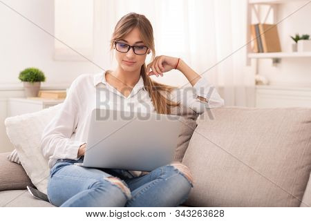 Online Education. Student Girl Using Laptop Watching Video Masterclass Sitting On Couch Spending Wee