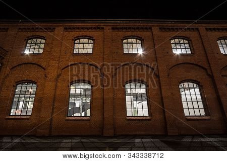 Facade Of A Vintage Old Red Brick Warehouse, Used From An Industrial Revolution Era Facotry Plant, W