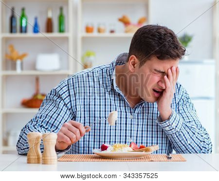 Man eating tasteless food at home for lunch