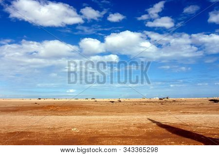 Fluffy Clouds Overt The Barren Desert In The Southern Oman