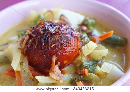 Lontong Sayur Or Rice Cake With Vegetable Stew Coconut Milk Served In A Bowl And Garnished With Frie