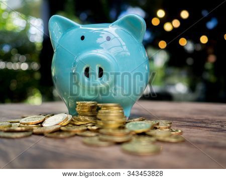 Blue Piggy Bank With 
Gold Coins Pile, Saving Money For Future Investment Plan And Retirement Fund C