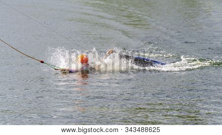 Child Wearing A Helmet For Safety Falls Off A Kneeboard At A Cable Park