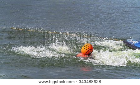 Child Wearing A Helmet For Safety Falls Off A Kneeboard At A Cable Park