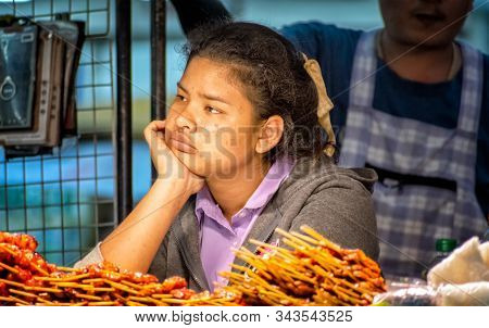 Bangkok, Thailand - January 05: Street Food Vendor Merchant Stares With Boredom As Business Slows Do