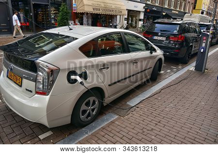 Amsterdam, Holland. August 2019. On The Road A Toyota Prius Plug In Is Parked In Recharge. The Charg