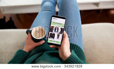 Close Up Of Woman Shopping For Clothes Online Using Mobile Phone App