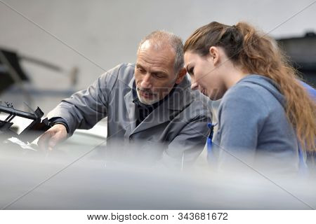 Apprentice with instructor working on vehicule