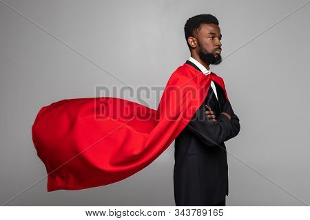 Side View Of African Businessman In Suit With Hero Red Cout On Gray Background