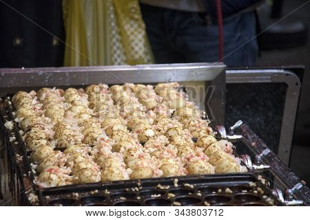 Vendor Making Takoyaki On A Takoyaki Pan In Osaka, Japan. Takoyaki Is Famous Street Food In Osaka.