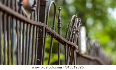 Pano Frame Close Up Of Rusty And Old Iron Fence On Top Of Stone Wall On A Sunny Day