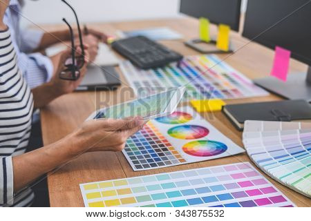 Two Colleagues Creative Graphic Designer Working On Color Selection And Drawing On Graphics Tablet A