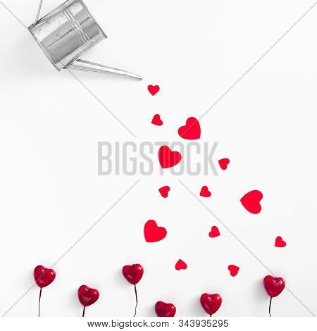 Silver Watering Can Pouring Red Hearts. Valentines Day Concept