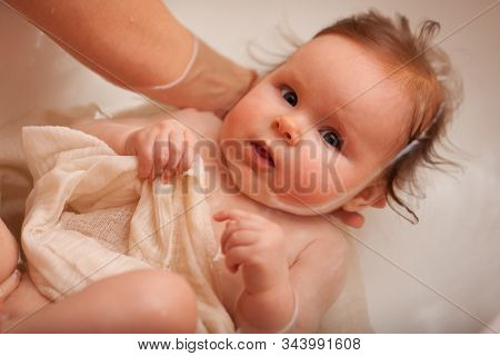 Cute Newborn Baby Bathes In The Bathroom. The Concept Of A Toddlers  Swimming