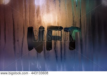 The Word Nft - Non-fungible Token Handwritten On Foggy Window Glass At Night.