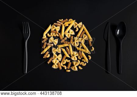 A Variety Of Pasta In The Shape Of A Plate And Black Plastic Cutlery On A Black Background For Menu 