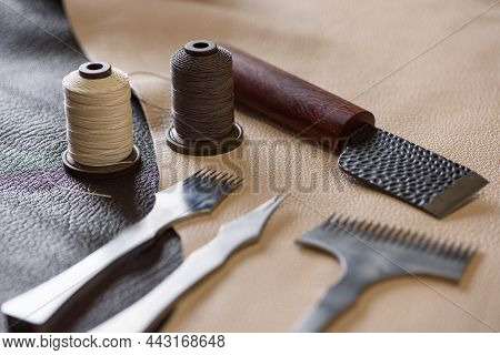 Shoemaker's Tools Laying On Piece Of Beige And Brown Genuine Leather In Workshop. Workplace Of Shoem