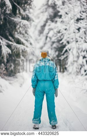 Woman In Ski Suit In Snowy Forest During Winter Vacations Outdoors
