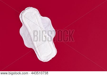 One Feminine Sanitary Pad, Napkin. Means Of Feminine Hygiene During The Menstrual Cycle. Red Backgro