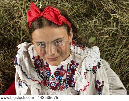 Salaj, Romania - May 15, 2018: Young Rural Girl Wearing Traditional Costumes Sitting In A Hayloft At