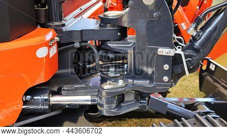 Excavator Pivot Joints. Coupling With Hydraulic Pipe Axis Of A New Small Orange Backhoe. Closeup And