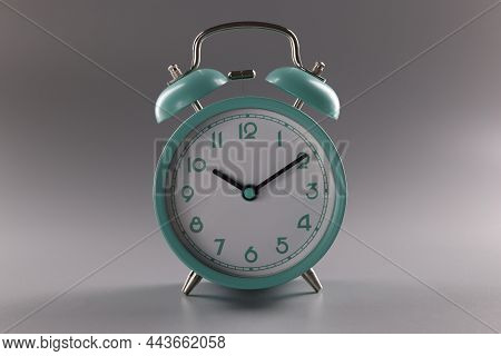 Close-up Of Single Simple Designed Green Retro Clock On Grey Surface. Metal Vintage Clock On Tiny Le