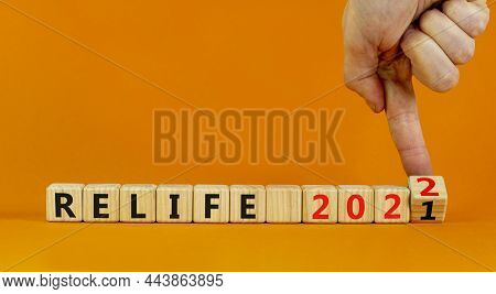 Planning 2022 Relife New Year Symbol. Businessman Turns Wooden Cubes And Changes Words 'relife 2021'