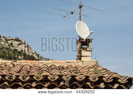 Old Tv Antenna And Modern Dish On Roof