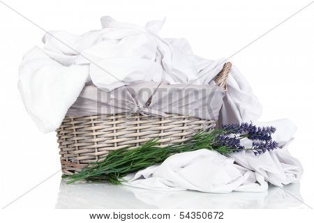 Rumpled bedding sheets in wicker basket isolated on white