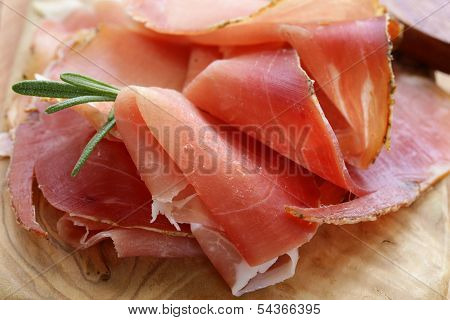 parma ham (jamon) sliced on a wooden board