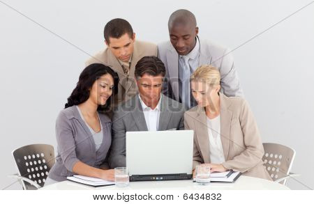 Equipo de negocios multiétnica trabajando juntos con un ordenador portátil