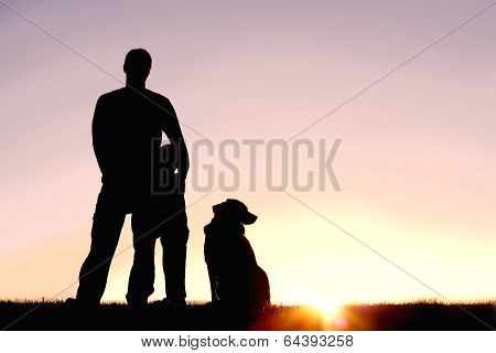 Father, Son, And Dog In Front Of Sunset Silhouette