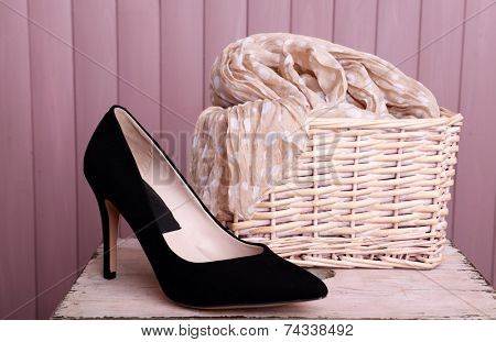 Black women shoes and scarf on bench on wooden background