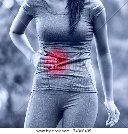 Side stitch - woman runner side cramps after running. Jogging woman with stomac side pain after jogging work out. Female athlete.