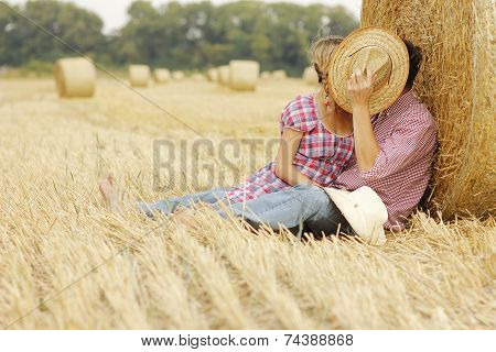 In Love Young Couple On Haystacks In Cowboy Hats