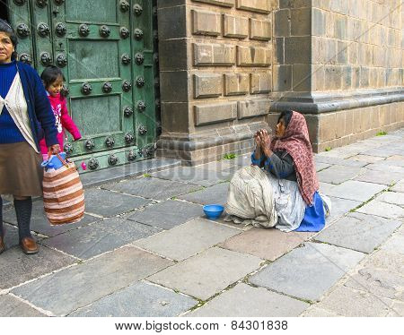 Poor People Beg For An Alm In Front Of The Basilica De La Cathedral