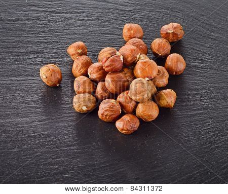 Heap Of Hazelnuts On A Dark Background