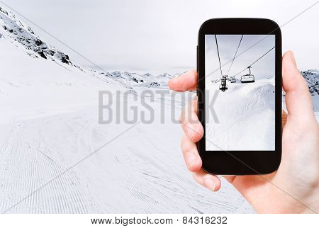 Tourist Taking Photo Of Skiing Tracks And Ski Lift