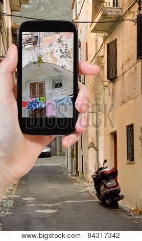 Tourist Taking Photo Of Side Street In Town