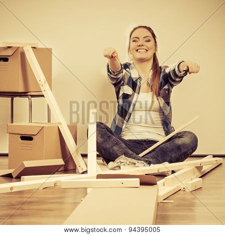 Woman Moving Into Apartment Assembly Furniture.