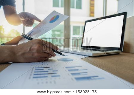 Asia business people discussing the charts and graphs showing the results of their successful teamwork.Vintage tone Retro filter effectsoft focuslow light.(selective focus)